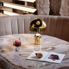 Tom Dixon Bell LED Portable Lamp - Gold in Restaurant